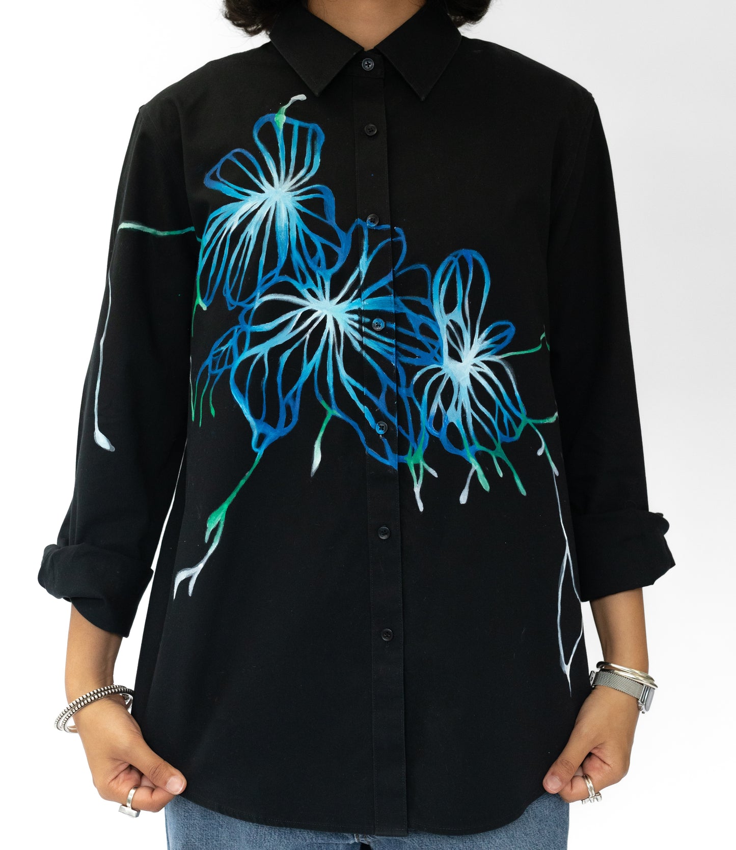 Black shirt with blue floral designs on a white background