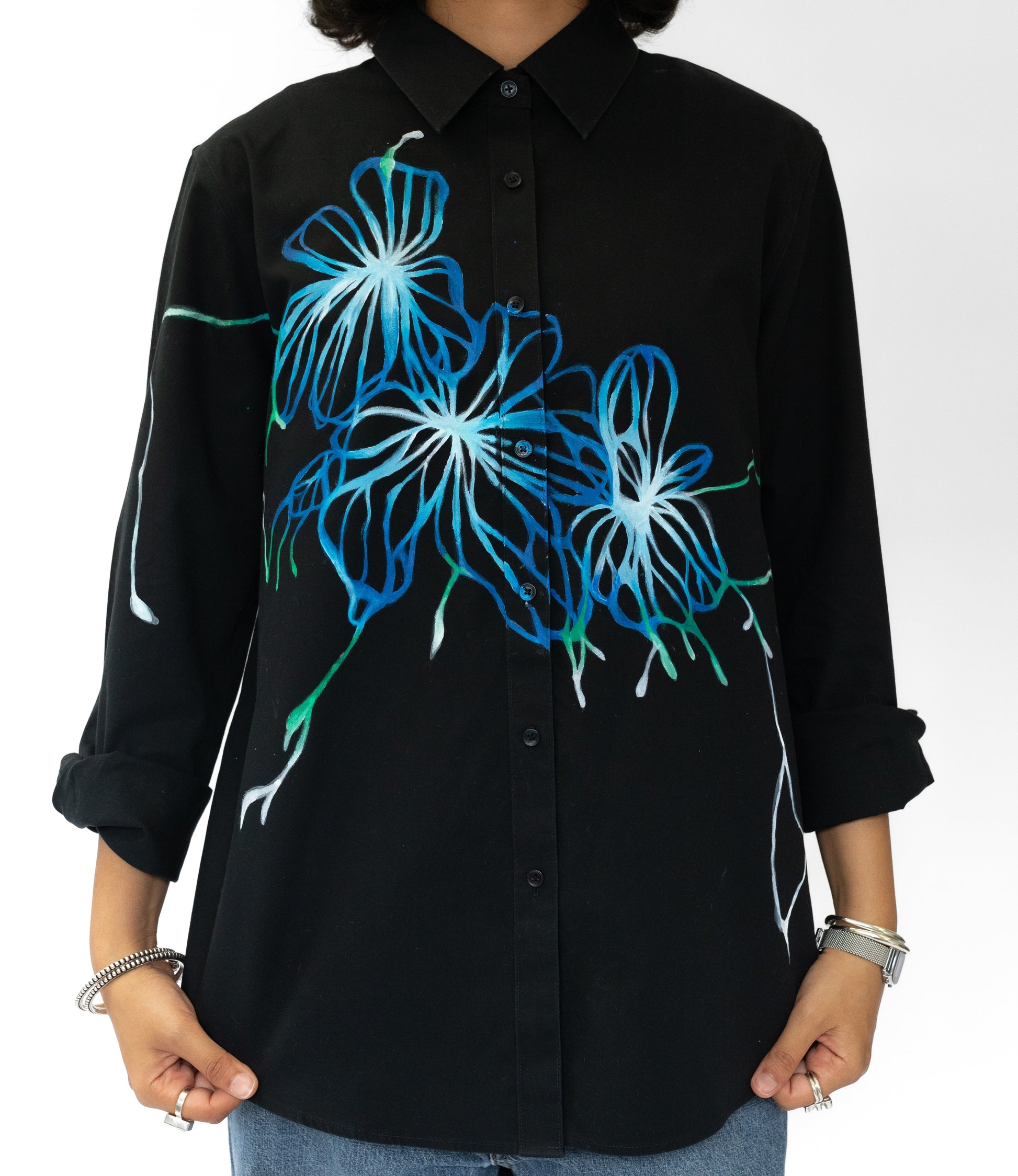 Black shirt with blue floral designs on a white background