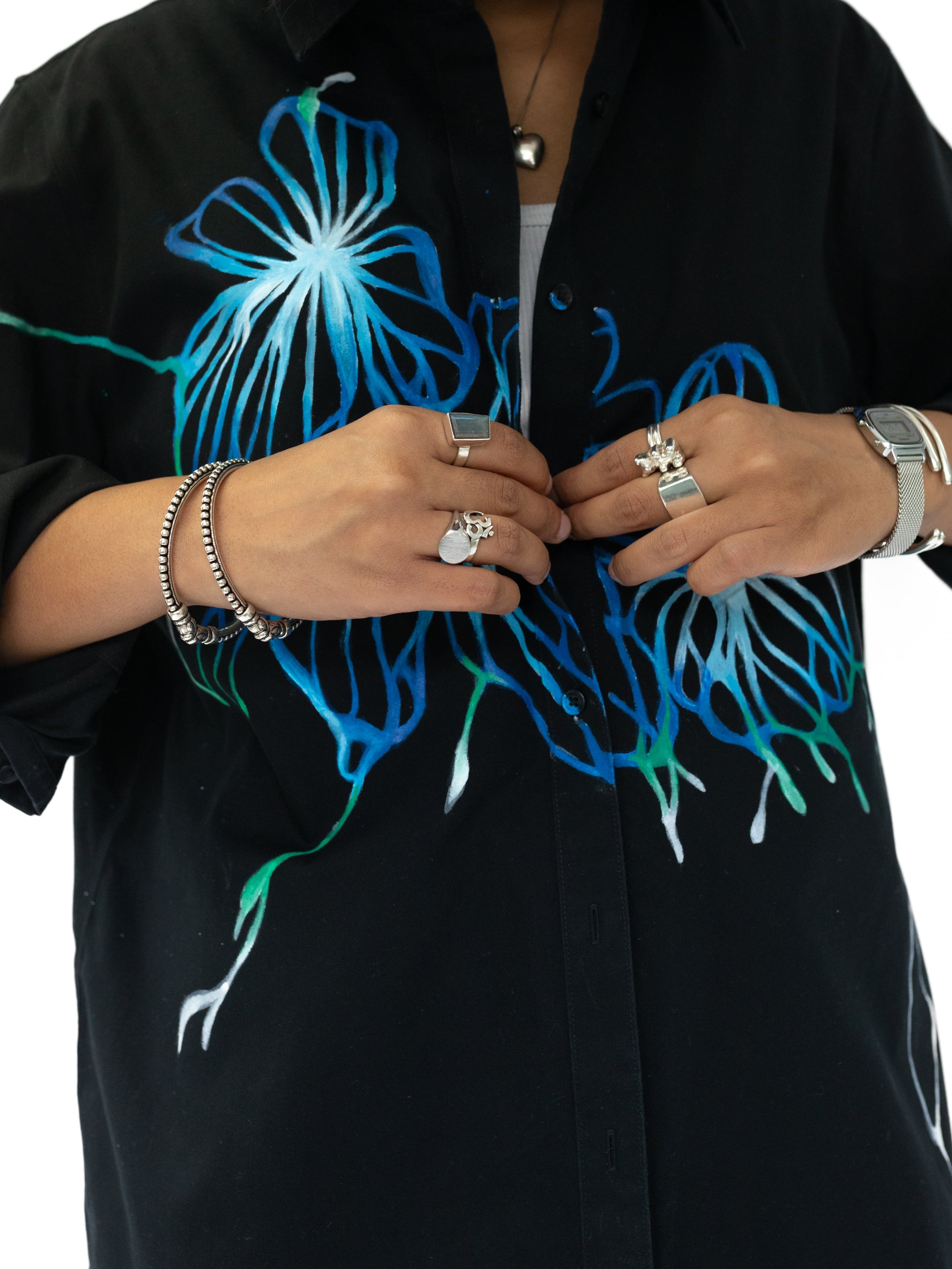 Black shirt with blue and green floral designs on a white background
