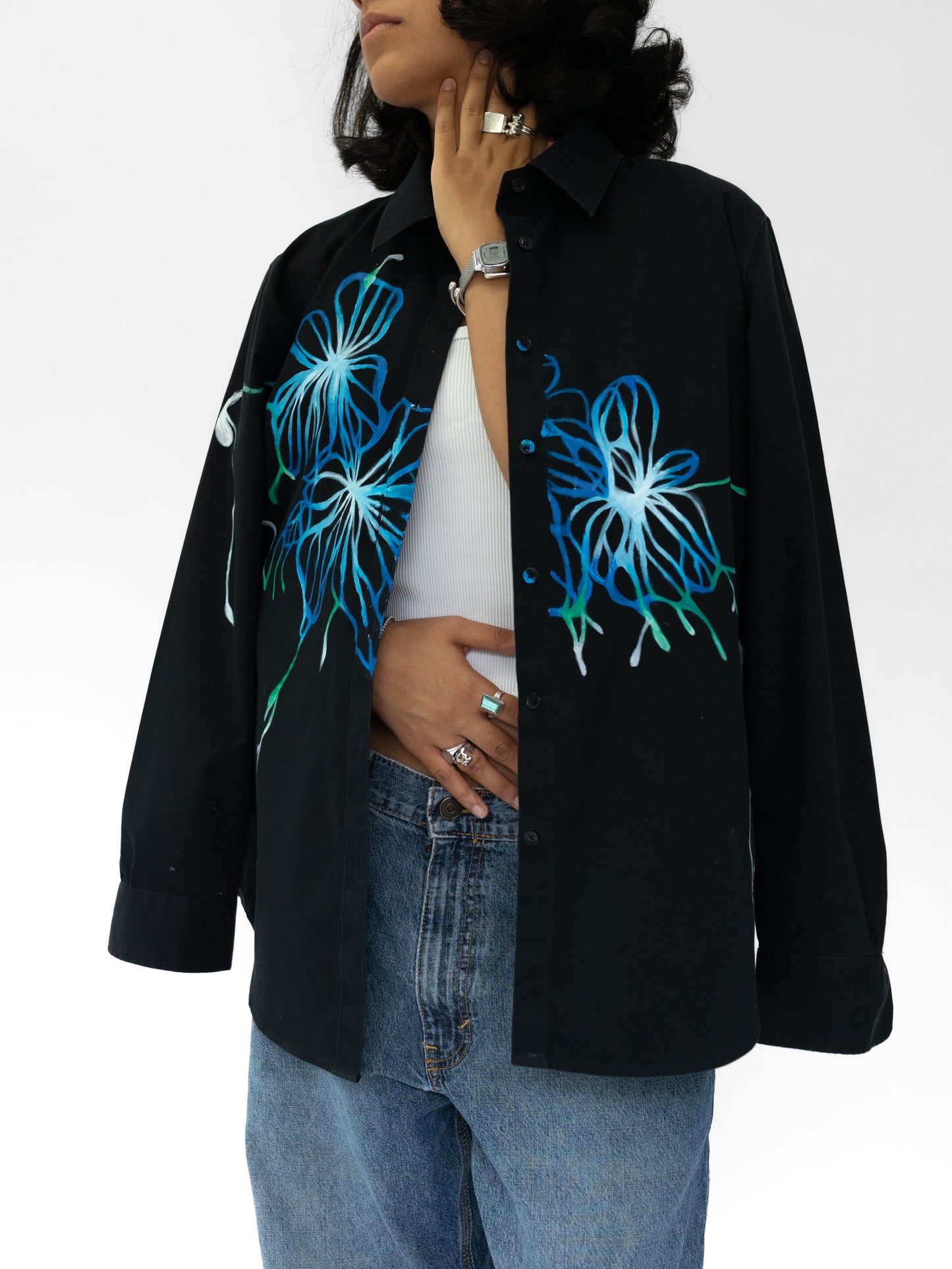 Person wearing a black shirt with blue floral designs on a white background