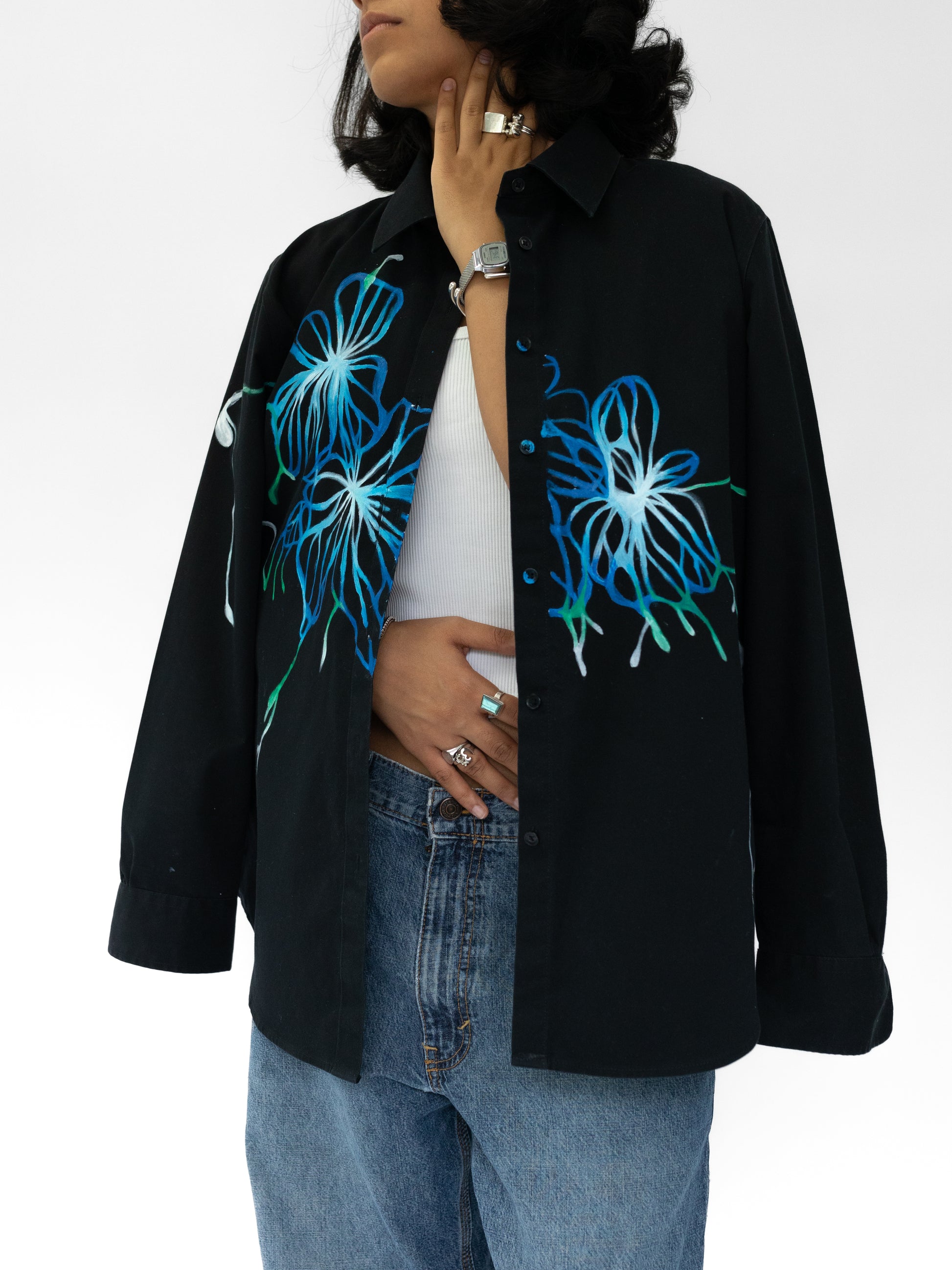 Person wearing a black shirt with blue floral designs on a white background
